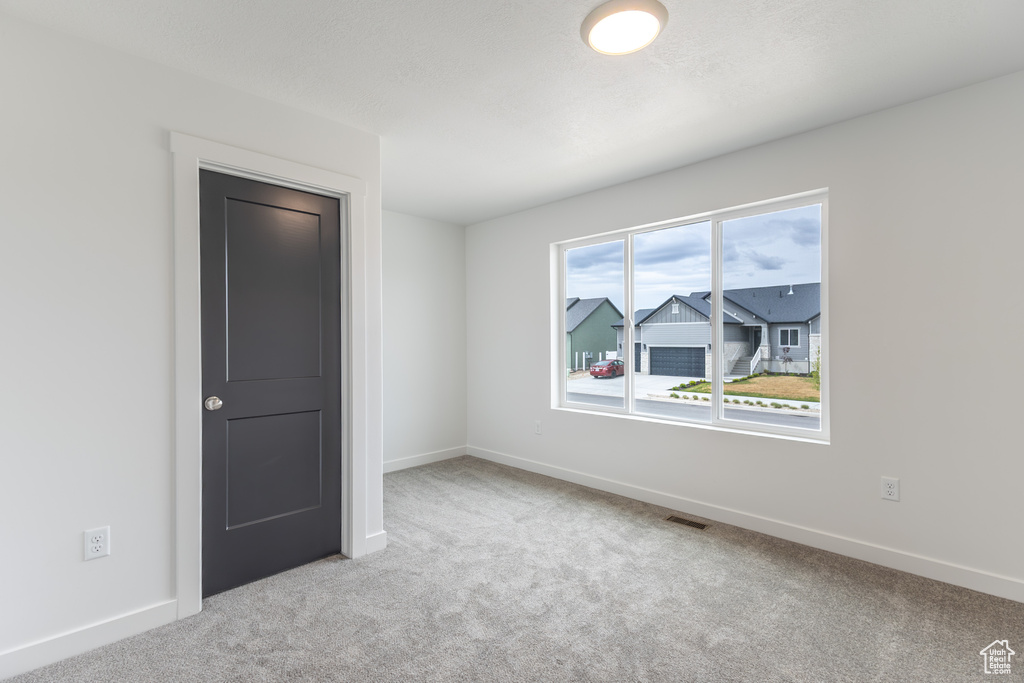 Spare room featuring carpet and baseboards