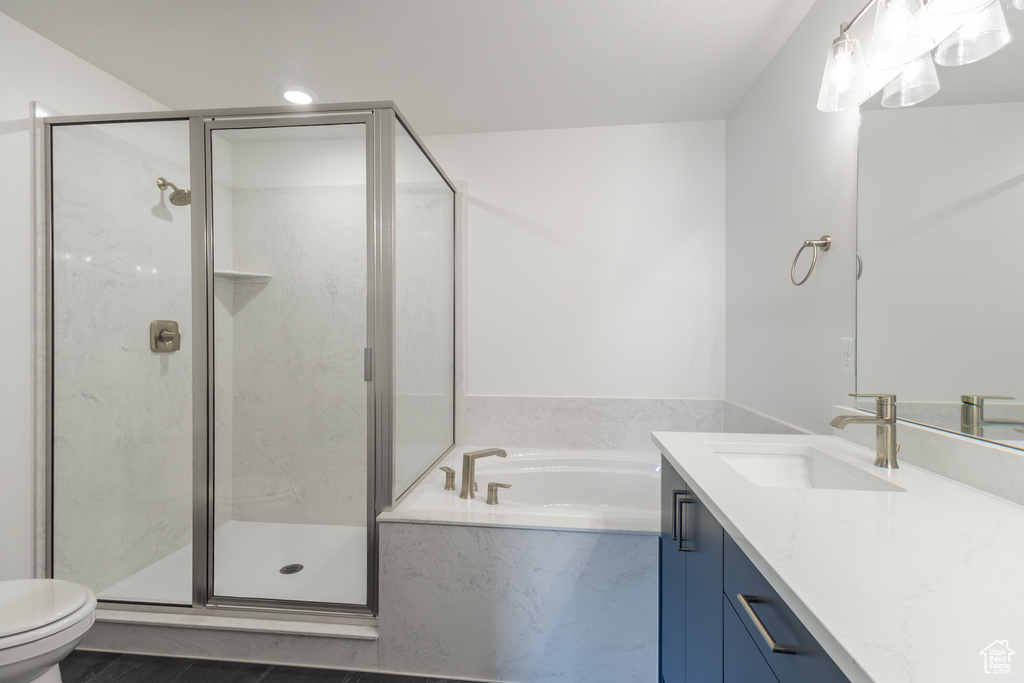 Full bathroom with toilet, vanity, a garden tub, and a marble finish shower