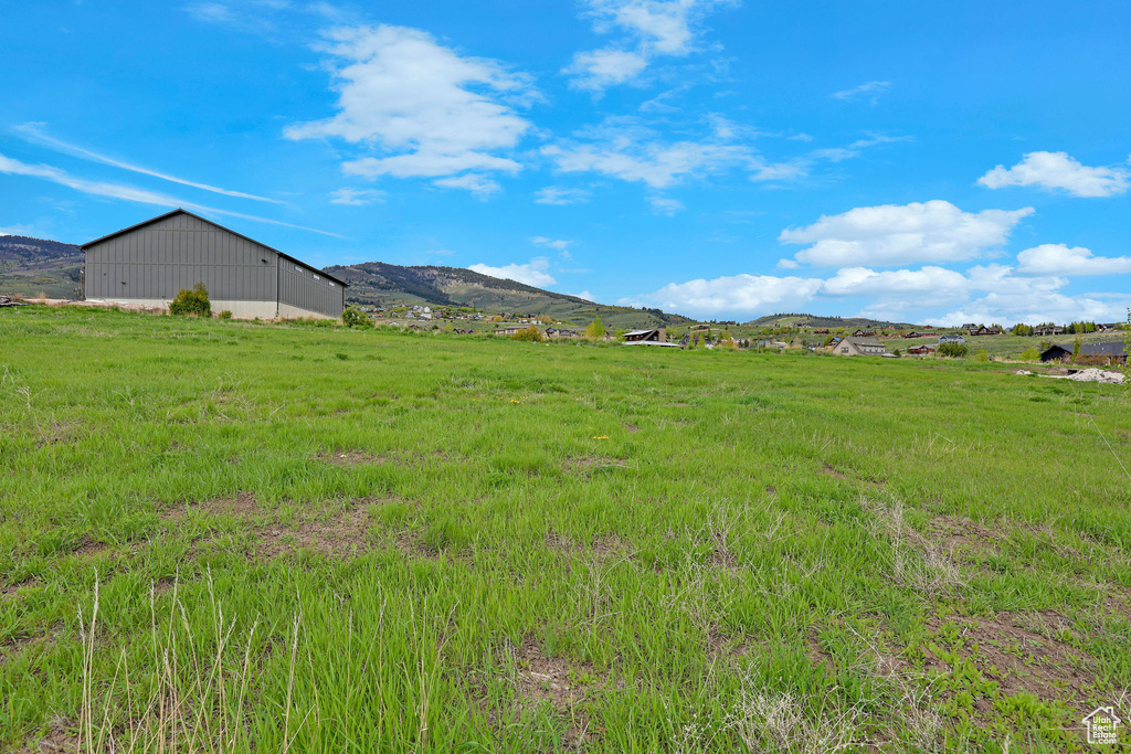 View of yard featuring a mountain view, a rural view, and an outbuilding