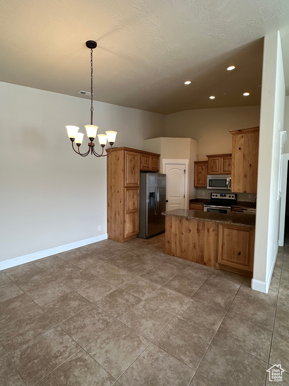 Kitchen featuring appliances with stainless steel finishes, a chandelier, a peninsula, baseboards, and recessed lighting