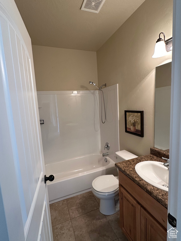 Full bathroom with shower / bathtub combination, toilet, tile patterned flooring, and vanity
