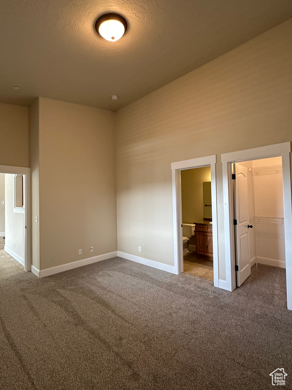 Unfurnished bedroom with carpet floors and baseboards