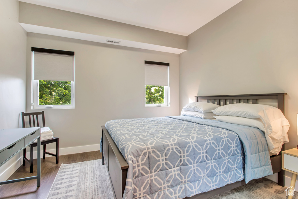 Bedroom with wood finished floors and baseboards