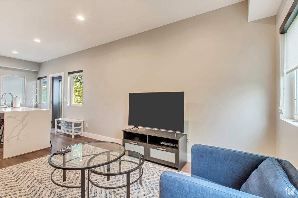 Living area with dark wood-style flooring, recessed lighting, and baseboards