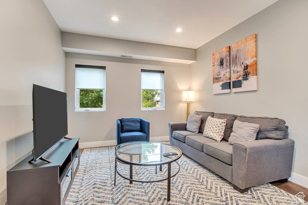 Living area featuring baseboards, wood finished floors, and recessed lighting