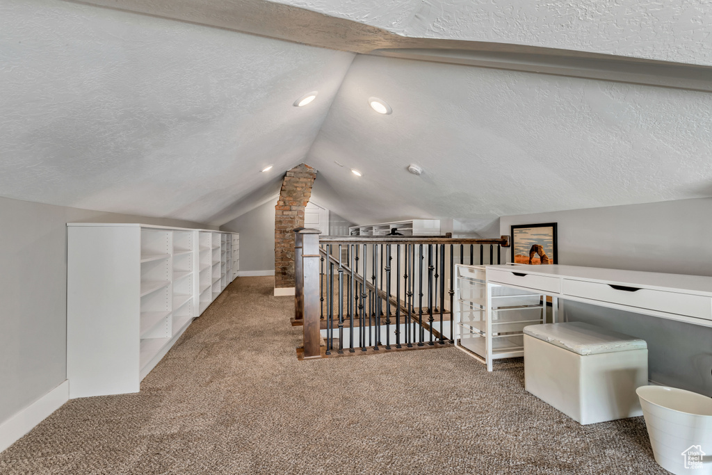 Bonus room with baseboards, vaulted ceiling, carpet flooring, and a textured ceiling