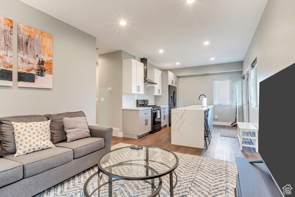 Living area featuring light wood finished floors, recessed lighting, and baseboards