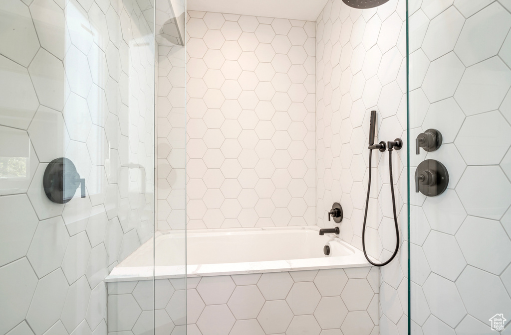 Full bath featuring tile walls