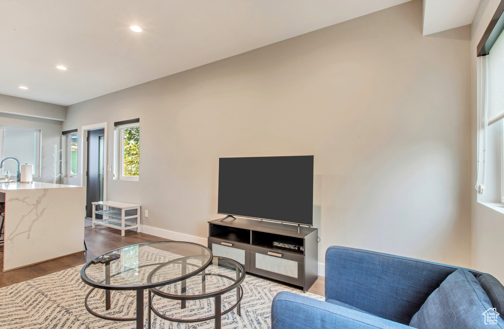Living area featuring dark wood-style flooring, recessed lighting, and baseboards