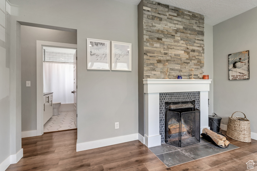 Living room featuring wood finished floors, a tiled fireplace, and baseboards