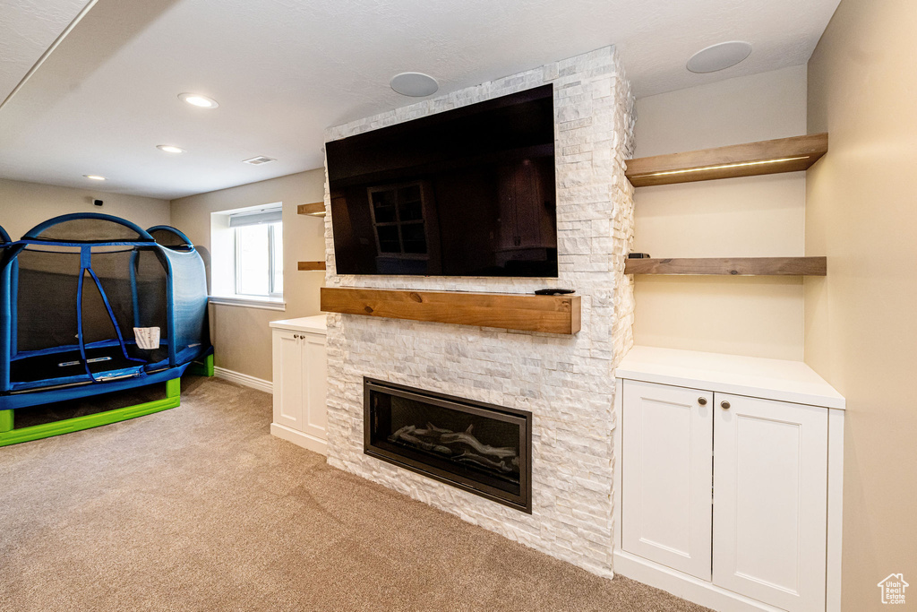 Rec room featuring light colored carpet, recessed lighting, a fireplace, and baseboards