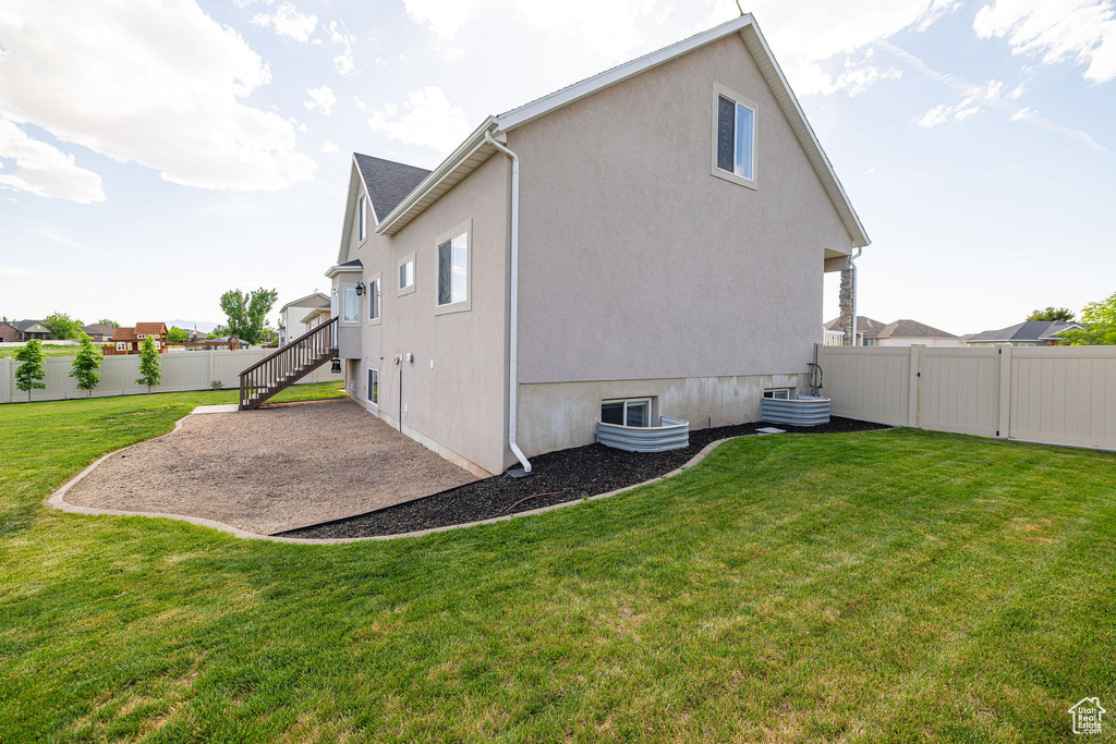 Rear view of house with a patio area, stucco siding, and stairs