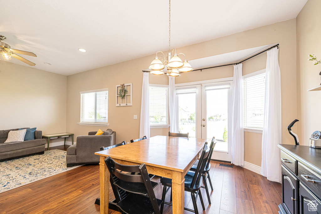 Dining area featuring dark wood finished floors, a chandelier, recessed lighting, french doors, and ceiling fan