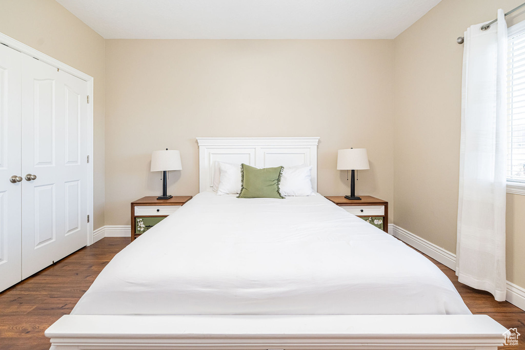 Bedroom with dark wood finished floors and baseboards