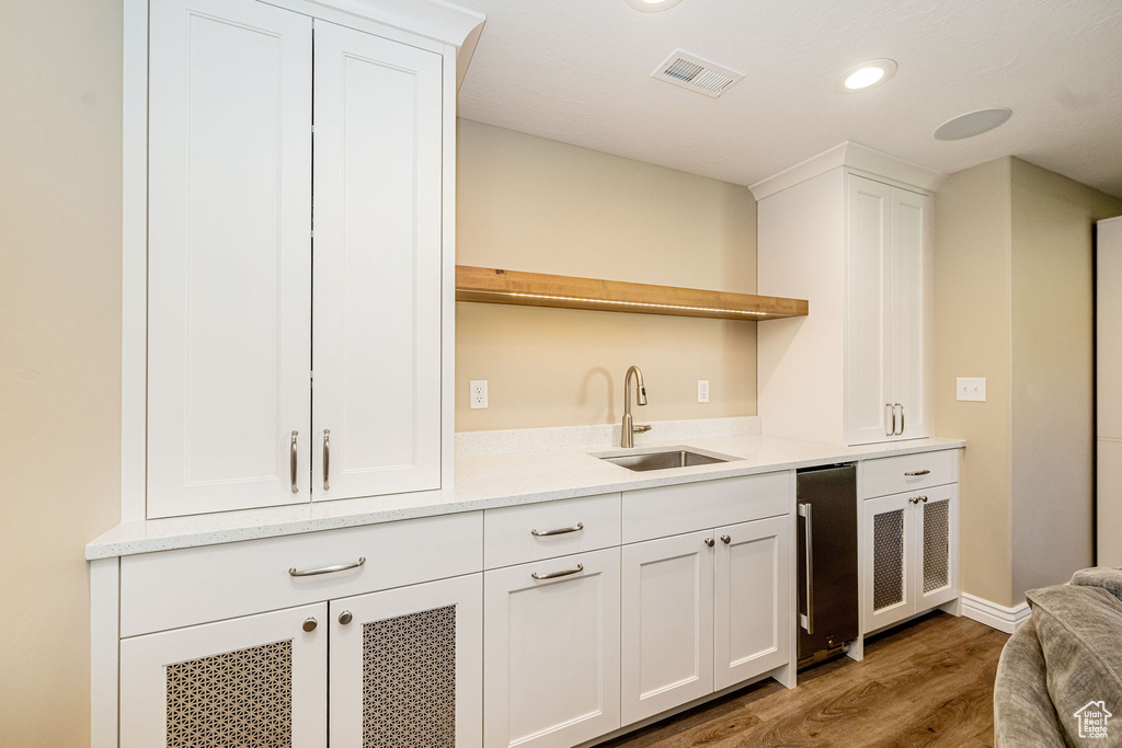 Indoor bar with light wood-style floors, recessed lighting, and baseboards