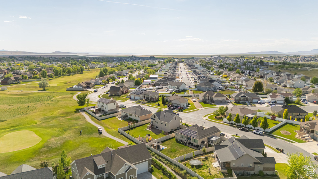 Aerial view of residential area with a mountainous background and a golf course