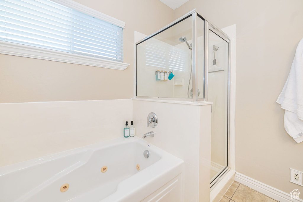 Bathroom featuring a shower stall, tile patterned flooring, and a tub with jets