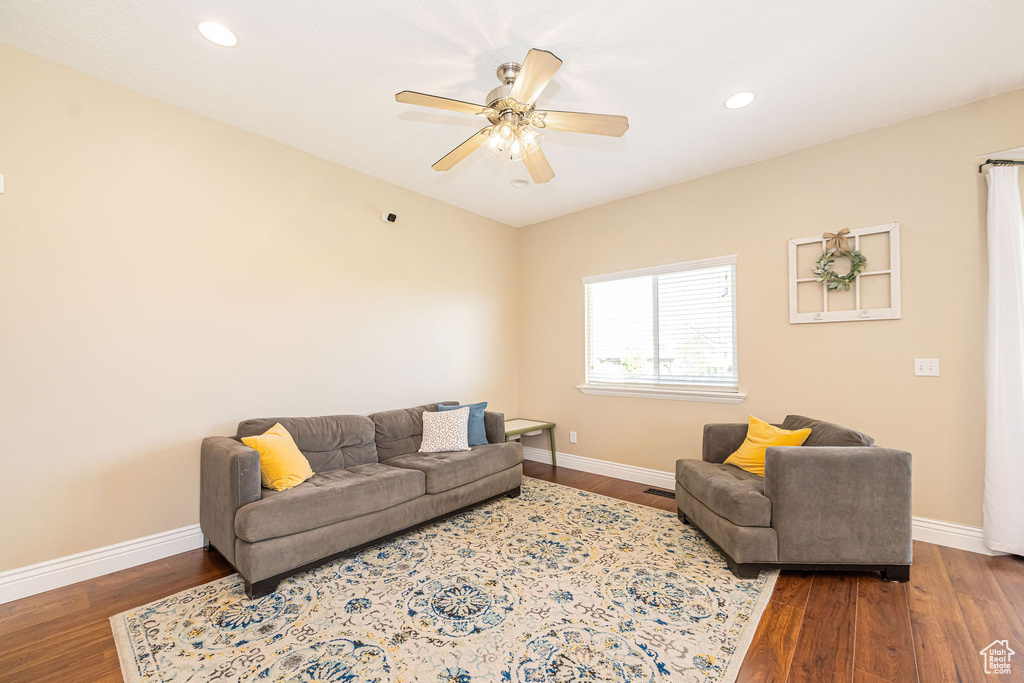 Living room featuring wood finished floors, baseboards, ceiling fan, and recessed lighting