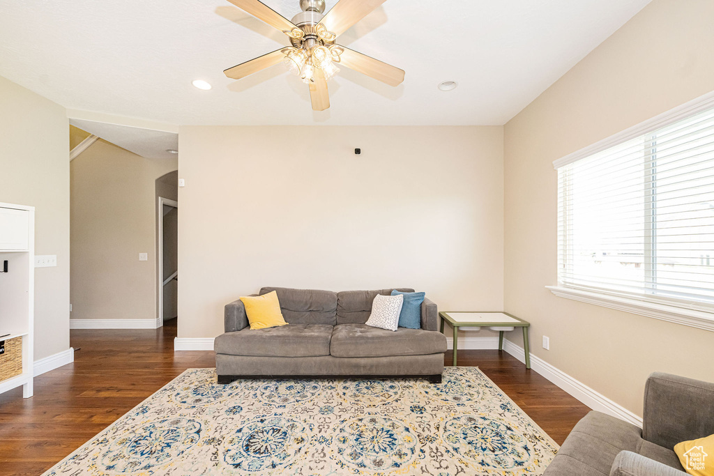 Living room with wood finished floors, a ceiling fan, baseboards, and recessed lighting