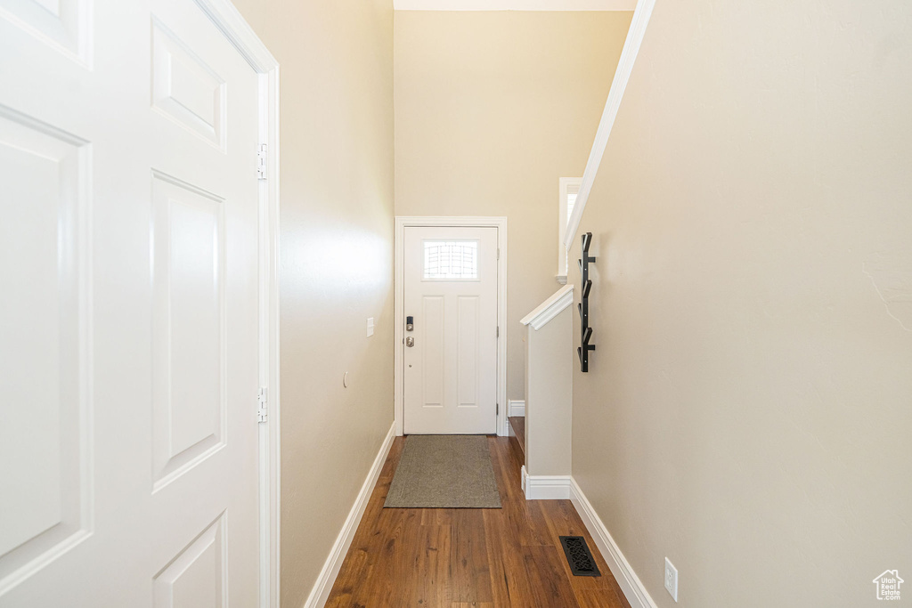 Doorway with wood finished floors and baseboards