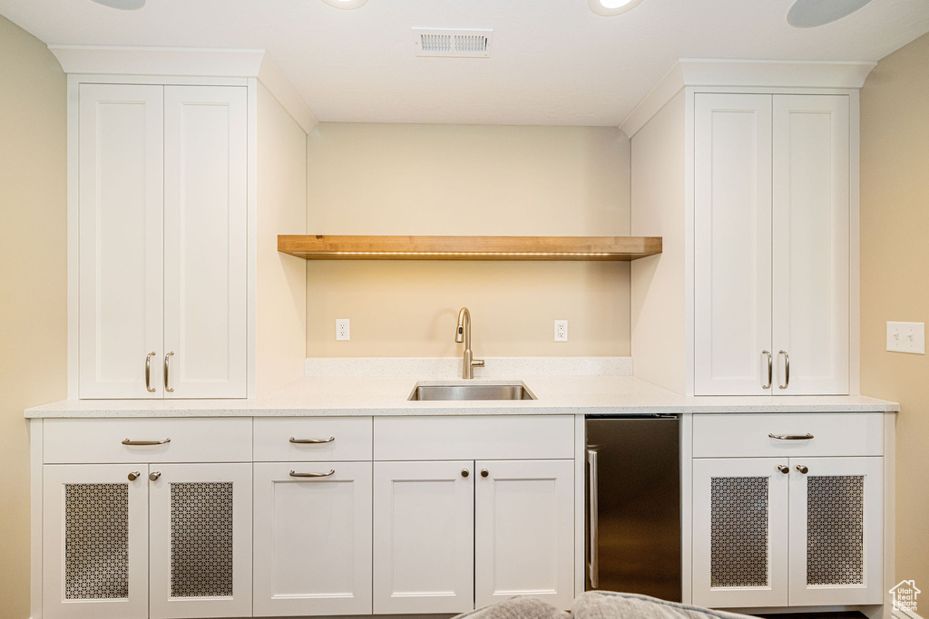 Bar area with a sink and stainless steel fridge