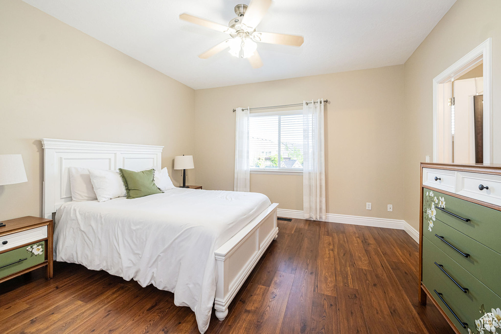 Bedroom with dark wood-type flooring, baseboards, and ceiling fan