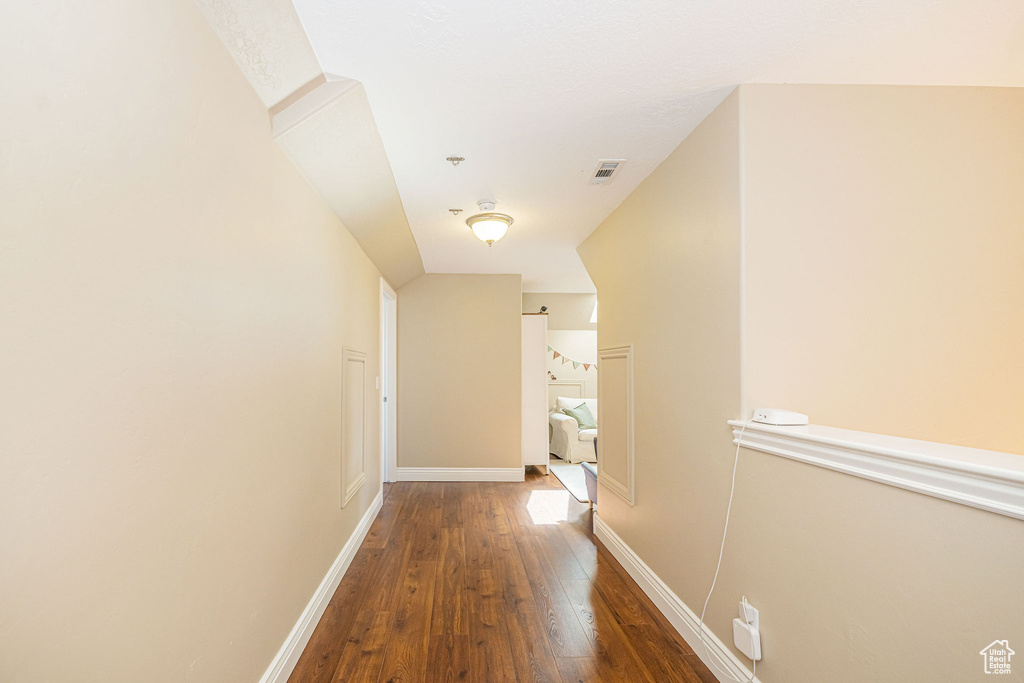 Corridor with hardwood / wood-style floors and baseboards