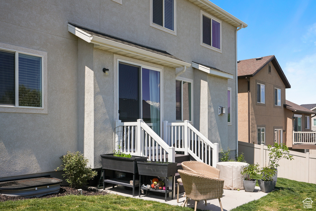 Back of house with stucco siding and fence