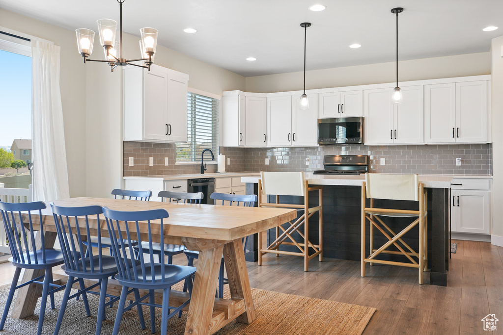 Kitchen featuring stainless steel microwave, gas stove, dishwasher, light countertops, and white cabinetry