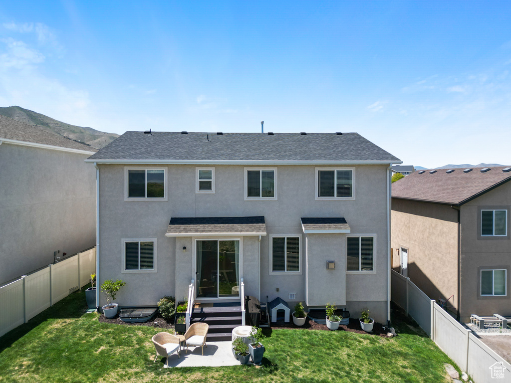Back of house featuring stucco siding and a shingled roof