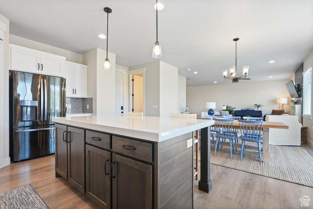 Kitchen with stainless steel fridge, light wood-style floors, open floor plan, tasteful backsplash, and recessed lighting