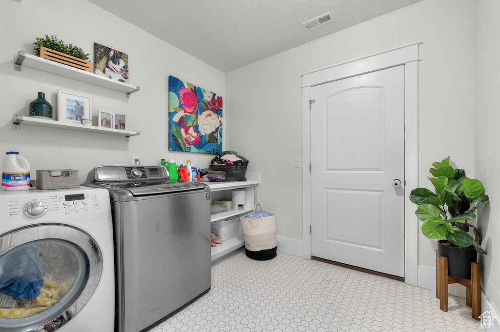 Clothes washing area featuring washer and clothes dryer and baseboards