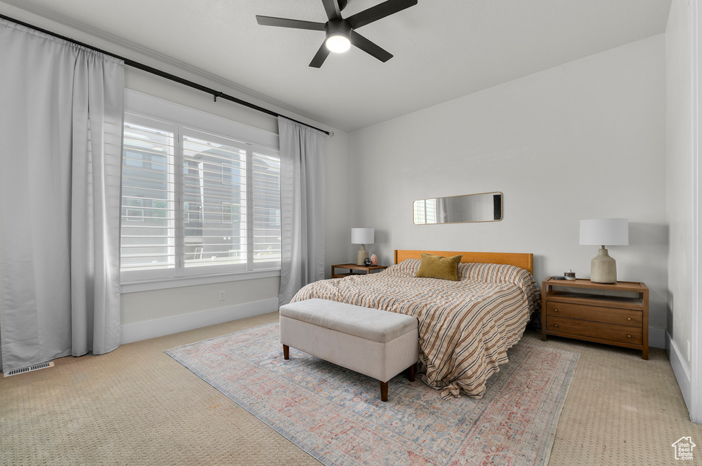 Carpeted bedroom with baseboards and a ceiling fan