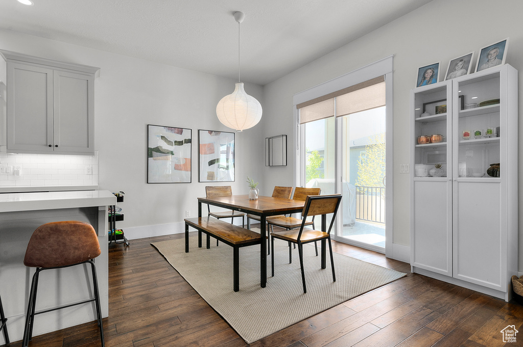 Dining area featuring dark wood-style flooring and baseboards