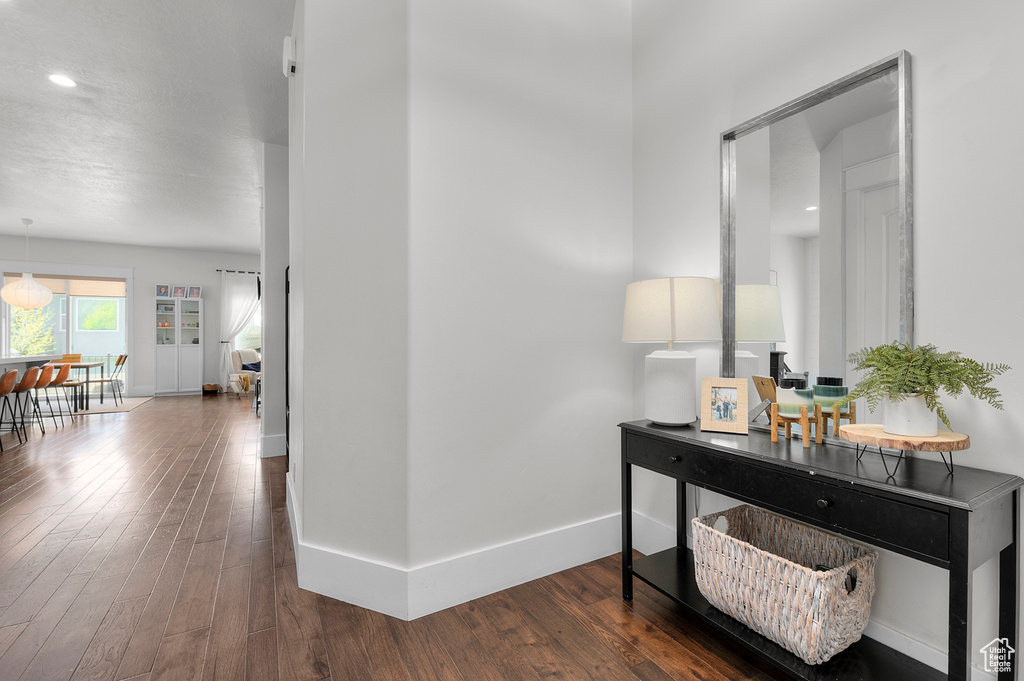 Hallway featuring wood finished floors, baseboards, and recessed lighting