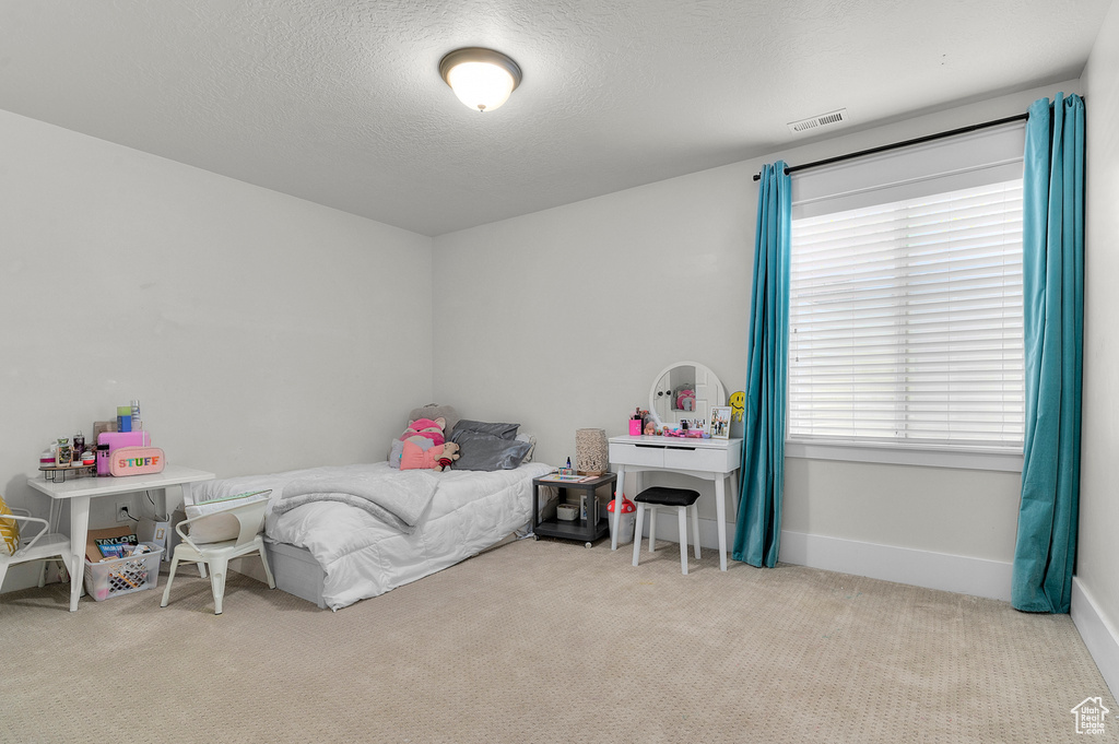 Carpeted bedroom with baseboards and a textured ceiling