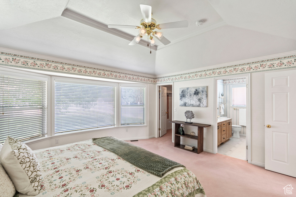 Bedroom featuring light carpet, multiple windows, ensuite bath, ceiling fan, and crown molding