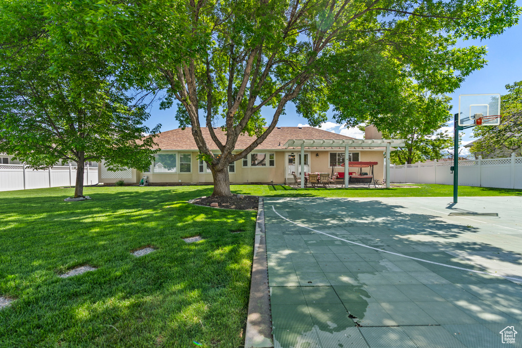 View of sport court with basketball hoop and a pergola