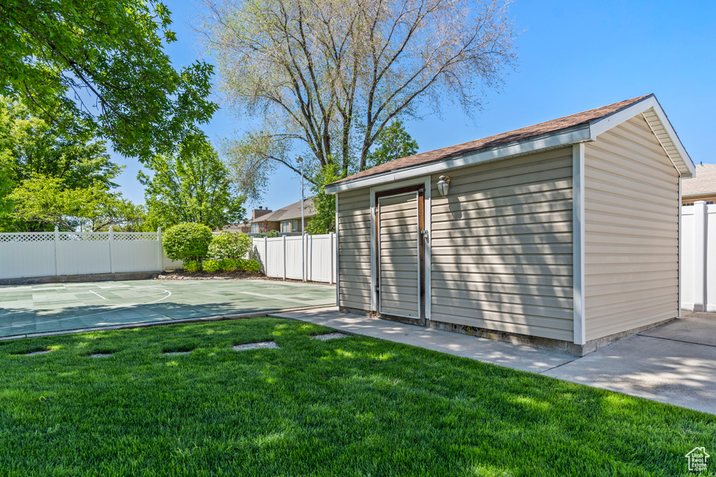 View of yard with an outdoor structure and basketball hoop
