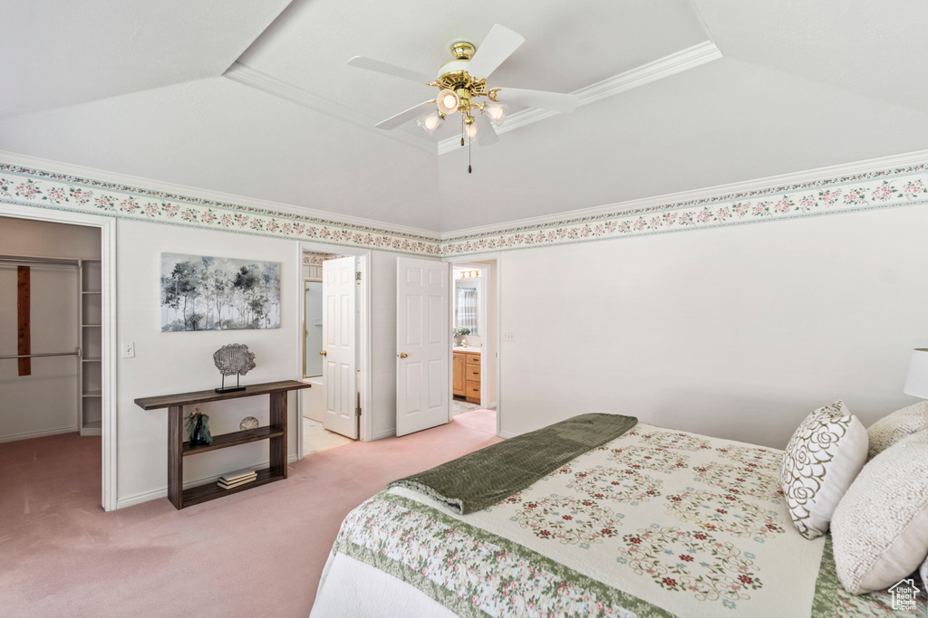 Bedroom featuring light carpet, a spacious closet, a closet, connected bathroom, and lofted ceiling