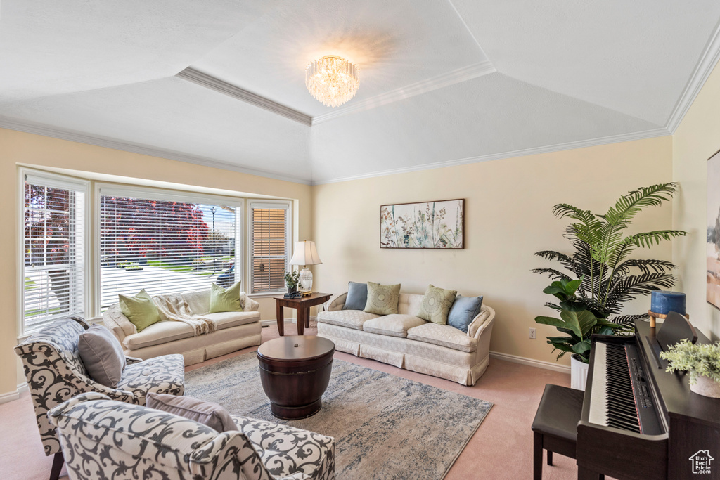 Living room with carpet flooring, a chandelier, a raised ceiling, crown molding, and baseboards
