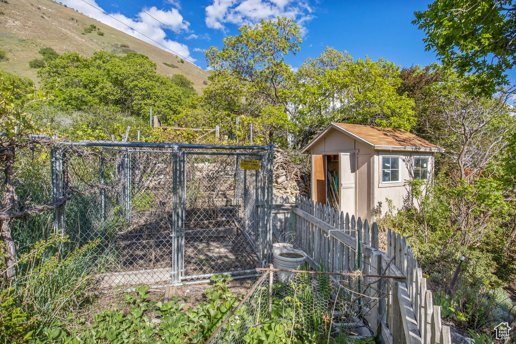 View of shed with fence and a gate