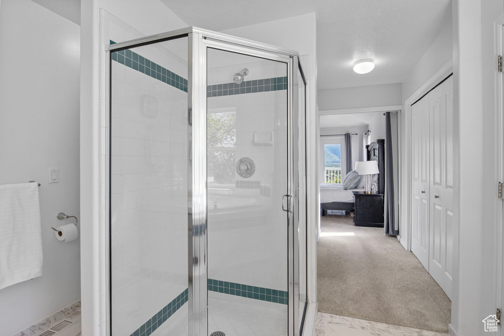 Bathroom with a shower stall and connected bathroom