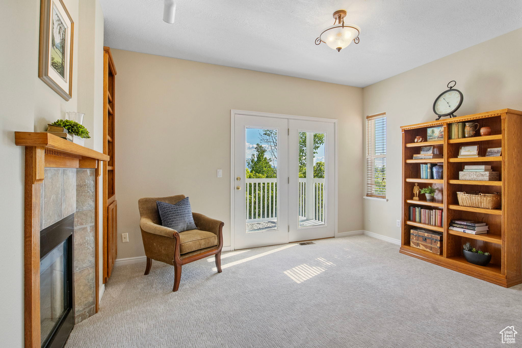 Sitting room featuring carpet, a fireplace, and baseboards