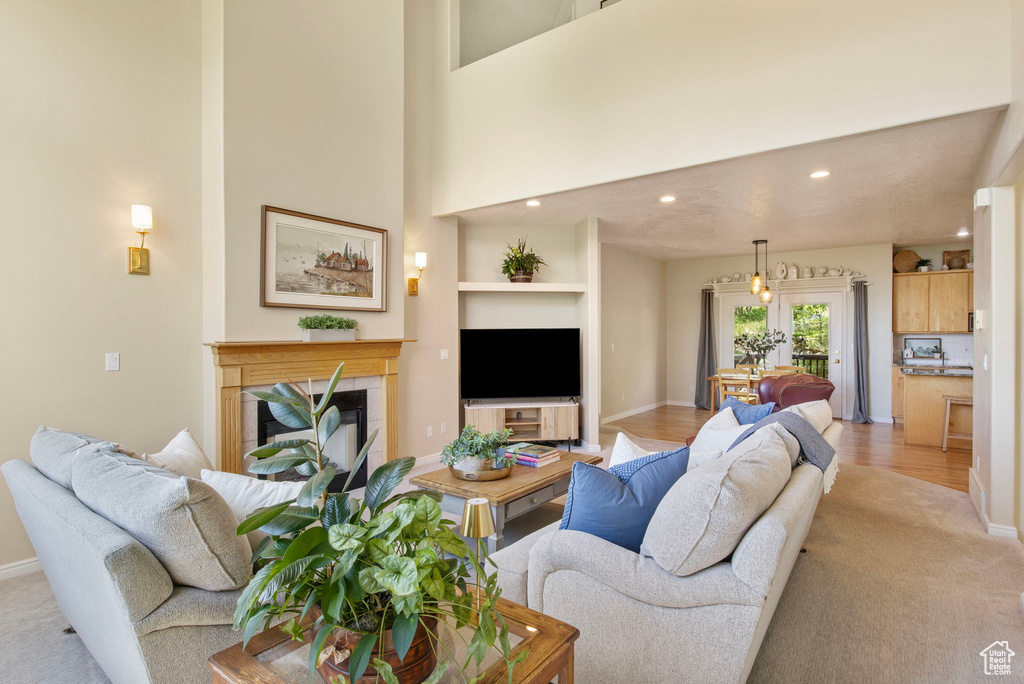 Living area featuring recessed lighting, a tiled fireplace, and baseboards
