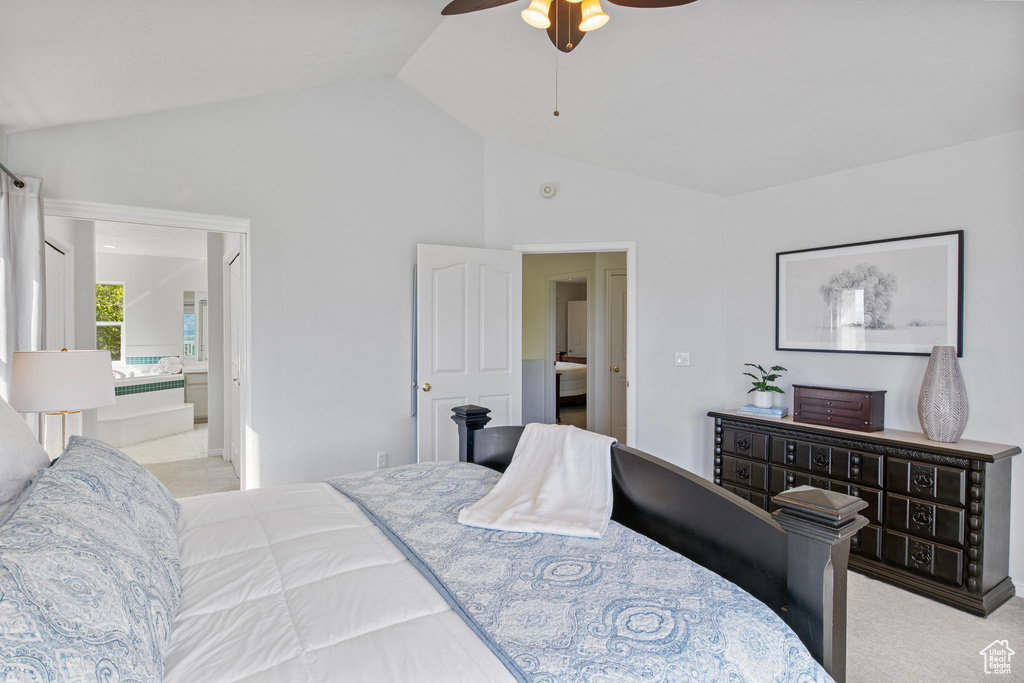 Bedroom featuring ensuite bathroom, ceiling fan, and high vaulted ceiling