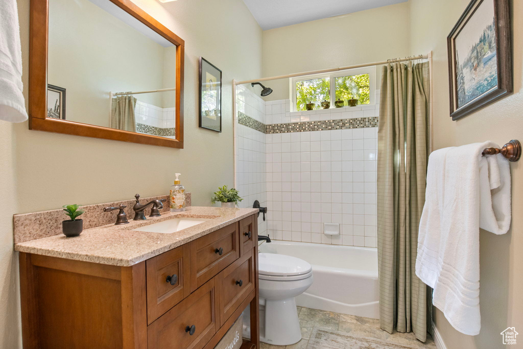 Bathroom featuring shower / tub combo with curtain, vanity, and toilet