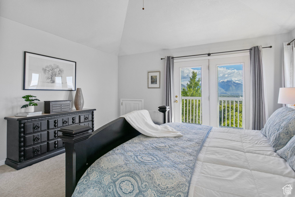 Carpeted bedroom with access to exterior and vaulted ceiling