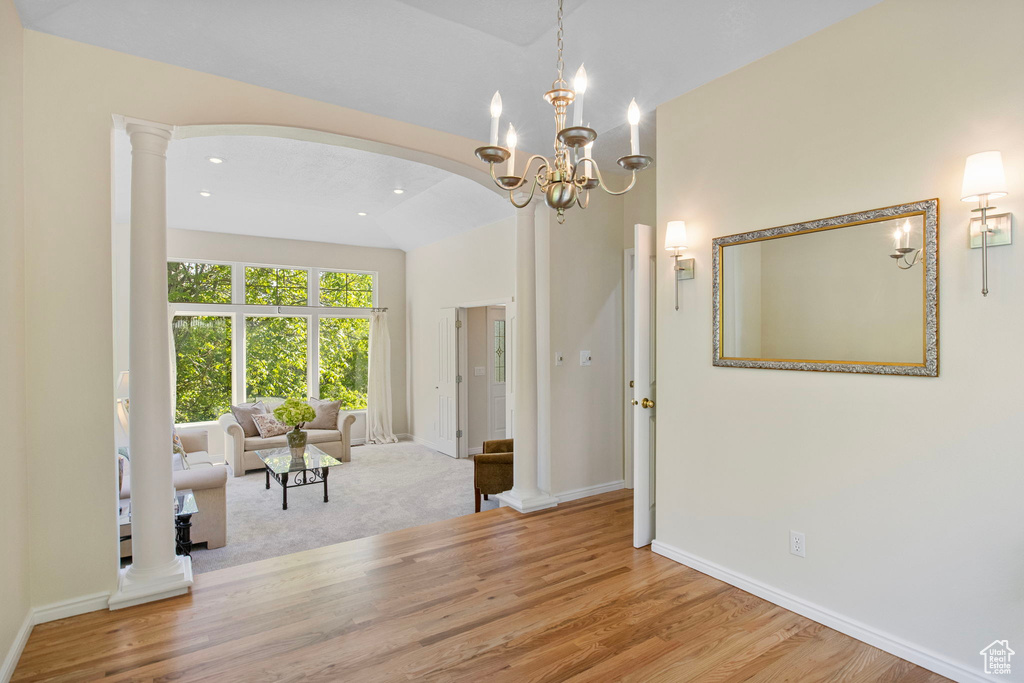 Interior space with wood finished floors, arched walkways, baseboards, recessed lighting, and a chandelier