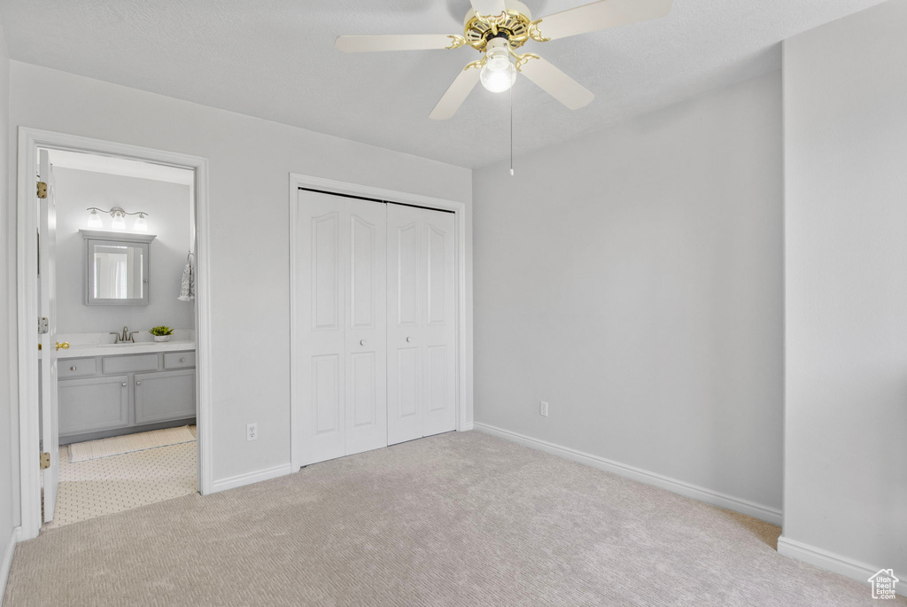 Unfurnished bedroom featuring light colored carpet, baseboards, and a sink